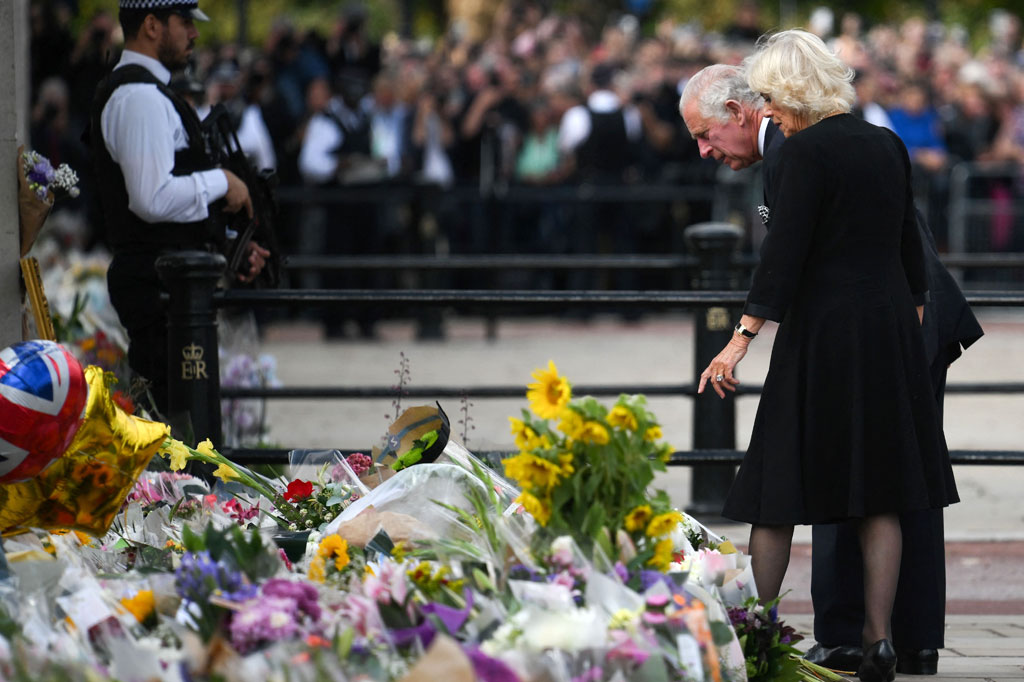 Charles, 73, yang mengenakan jas hitam, dasi, dan kemeja putih, setelah itu berjalan untuk melihat beberapa karangan bunga dan ucapan bela sungkawa yang ditinggalkan di gerbang istana untuk mendiang ibunya.