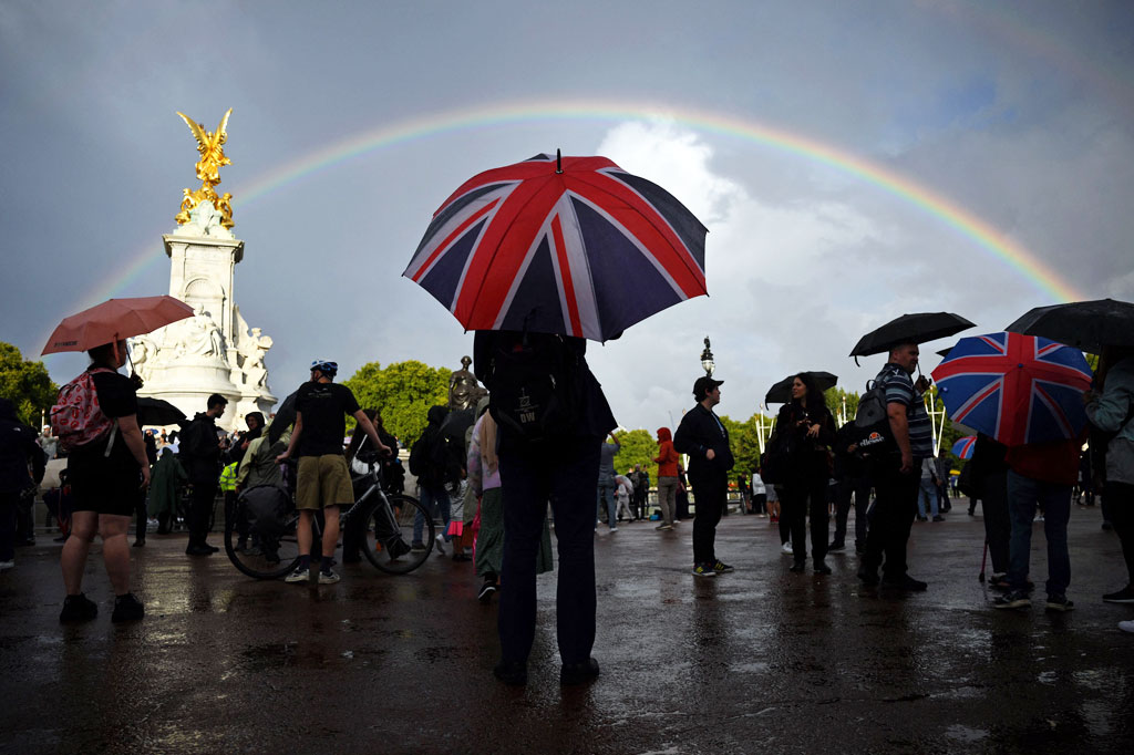 Pengunjung berada di seberang Istana Buckingham saat pelangi menghiasi Istana Buckingham seusai pengumuman wafatnya Ratu Elizabeth II di London, Inggris, kamis, 8 September 2022. 