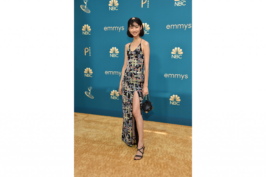 Hoyeon Jung. Bintang Squid Game ini hadir memakai gaun bermotif geometris berupa payet tambal sulam kaya warna di atas kain hitam yang unik dari Louis Vuitton.