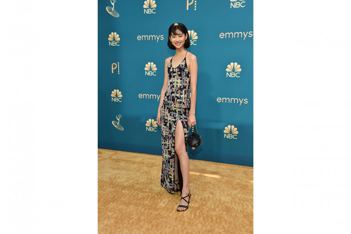 Hoyeon Jung. Bintang Squid Game ini hadir memakai gaun bermotif geometris berupa payet tambal sulam kaya warna di atas kain hitam yang unik dari Louis Vuitton.