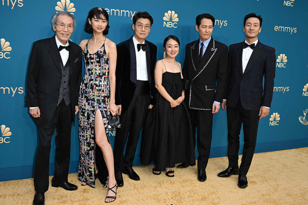 Penampilannya dilengkapi tas tangan mungil berwarna hitam dengan sepatu hak tinggi senada. Kali ini, rambutnya ditata dengan model bob, poni menyamping serta hiasan rambut berbentuk bunga di puncak kepalanya.