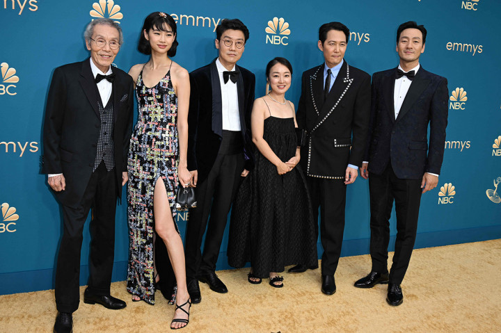 Penampilannya dilengkapi tas tangan mungil berwarna hitam dengan sepatu hak tinggi senada. Kali ini, rambutnya ditata dengan model bob, poni menyamping serta hiasan rambut berbentuk bunga di puncak kepalanya.