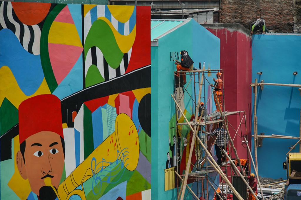 Petugas menyelesaikan pembuatan mural di Kampung Gembira Gembrong di Jakarta Timur, Rabu, 14 September 2022.