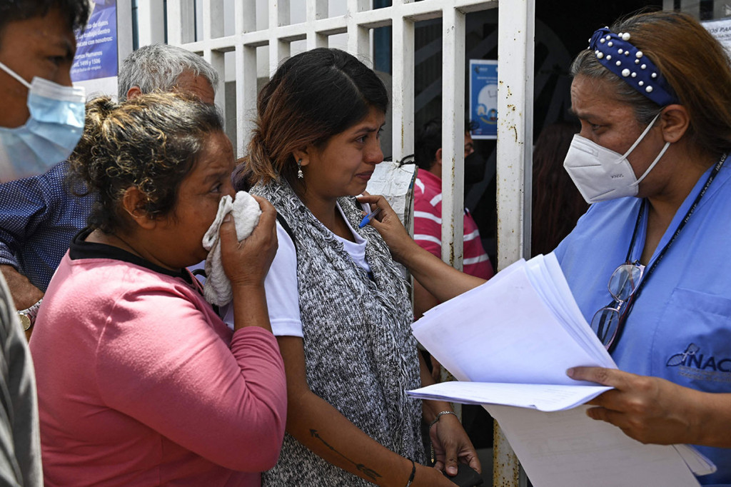 Seorang dokter forensik berbicara dengan kerabat korban di luar Institut Ilmu Forensik di Quetzaltenango, 200km barat Guatemala City, pada Kamis, 15 September 2022. 