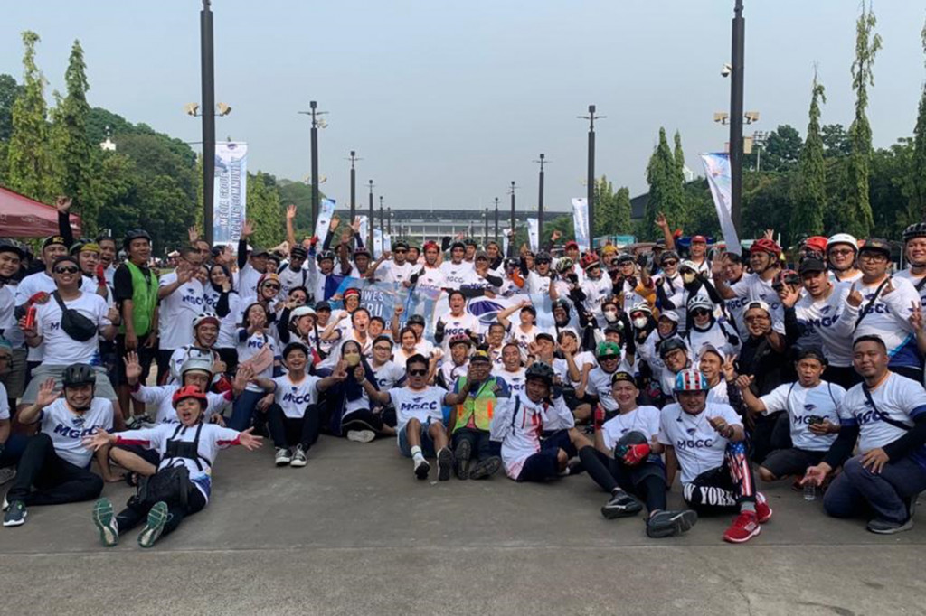 Karyawan Media Group berfoto bersama saat mengikuti gowes bareng  bersamaan dengan car free day di Jalan Sudirman-Thamrin, Jakarta, Minggu, 18 September 2022.