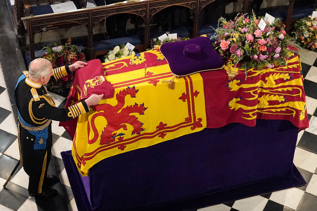 Raja Charles III menempatkan Queen's Company Camp Color of the Grenadier Guards di peti mati Ratu Elizabeth II saat proses pemakaman di Kapel St George di Kastil Windsor.