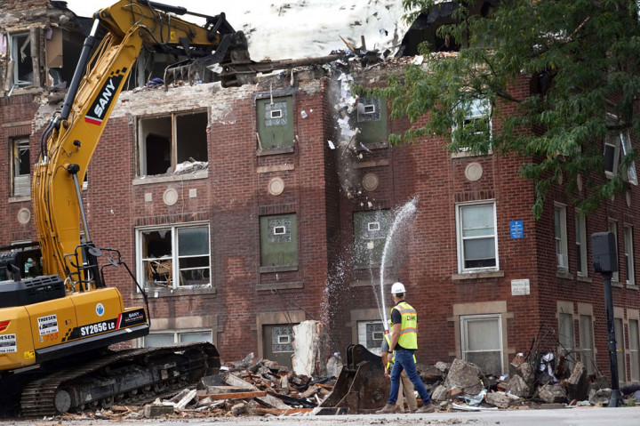Pekerja membersihkan dan mengamankan gedung apartemen yang rusak berat akibat ledakan di Chicago, Illinois, Amerika Serikat pada 20 September 2022.