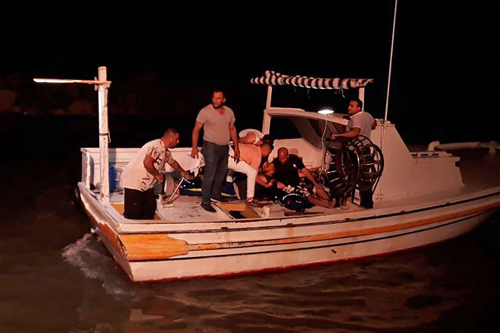Tim penyelamat mencari korban dan penyintas di lepas pantai kota pelabuhan selatan Suriah, Tartus, setelah sebuah kapal yang membawa migran dari Lebanon terbalik di laut Mediterania pada 22 September 2022.