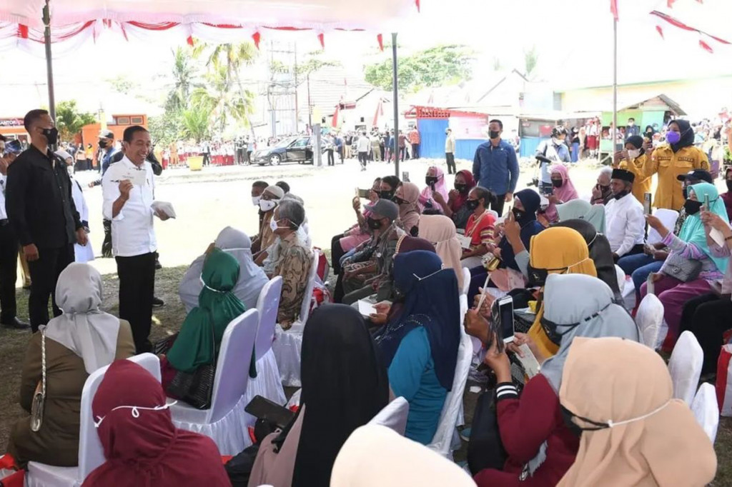 Presiden Joko Widodo menyapa warga saat meninjau pelaksanaan pemberian Bantuan Subsidi Upah (BSU) dan Bantuan Langsung Tunai (BLT) Bahan Bakar Minyak (BBM) di Kantor Pos Cabang Banabungi, Kabupaten Buton pada Selasa, 27 September 2022.