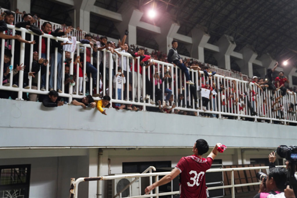 Pemain timnas Indonesia Elkan Baggot melempat syal ke suporter seusai pertandingan melawan Curacao di Stadion Pakansari, Bogor, Jawa Barat, tadi malam.