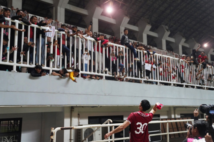Pemain timnas Indonesia Elkan Baggot melempat syal ke suporter seusai pertandingan melawan Curacao di Stadion Pakansari, Bogor, Jawa Barat, tadi malam.