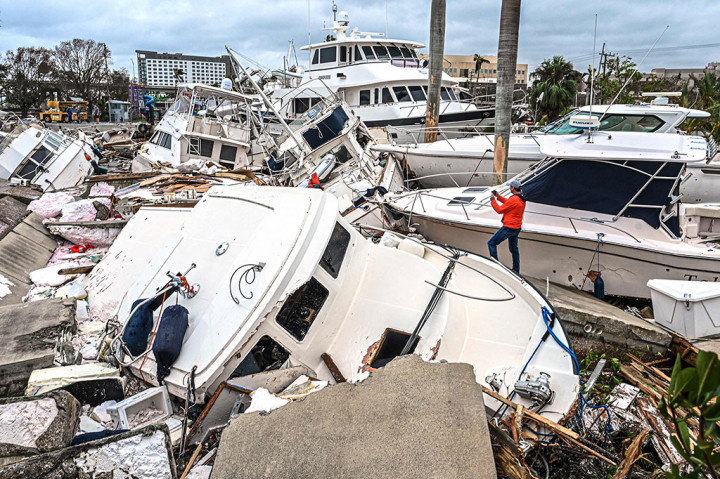 Seorang pria mengambil foto perahu yang tumpukan satu sama lain akibat diterjang Badai Ian di Fort Myers, Florida, pada Kamis, 29 September 2022 waktu setempat. 