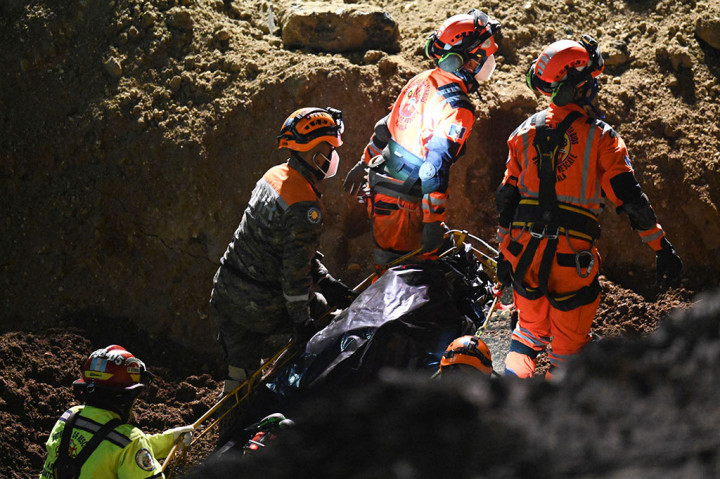 Petugas penyelamat mengevakuasi jenazah dua perempuan yang ditarik keluar dari sebuah kendaraan yang terperosok di lubang besar di Villa Nueva, 15 km selatan Guatemala City, pada Kamis, 29 September 2022 waktu setempat.