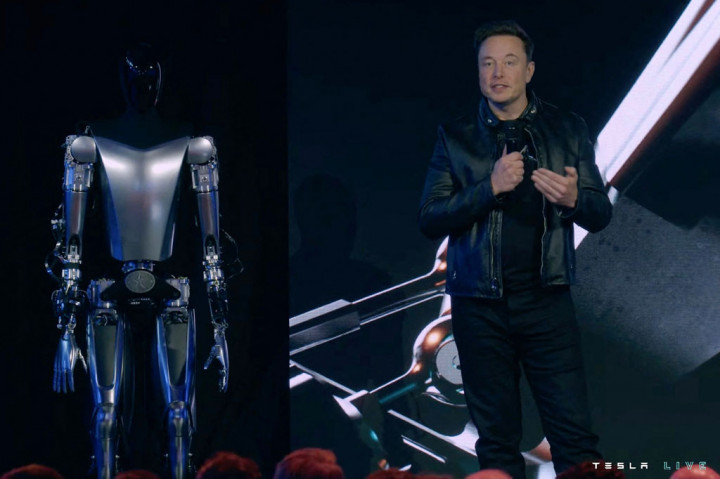 Pendiri Tesla, Elon Musk berdiri di atas panggung di samping Optimus, si robot humanoid, di Palo Alto, California pada Jumat, 30 September 2022. Optimus dipamerkan dalam ajang Tesla AI Day 2022.