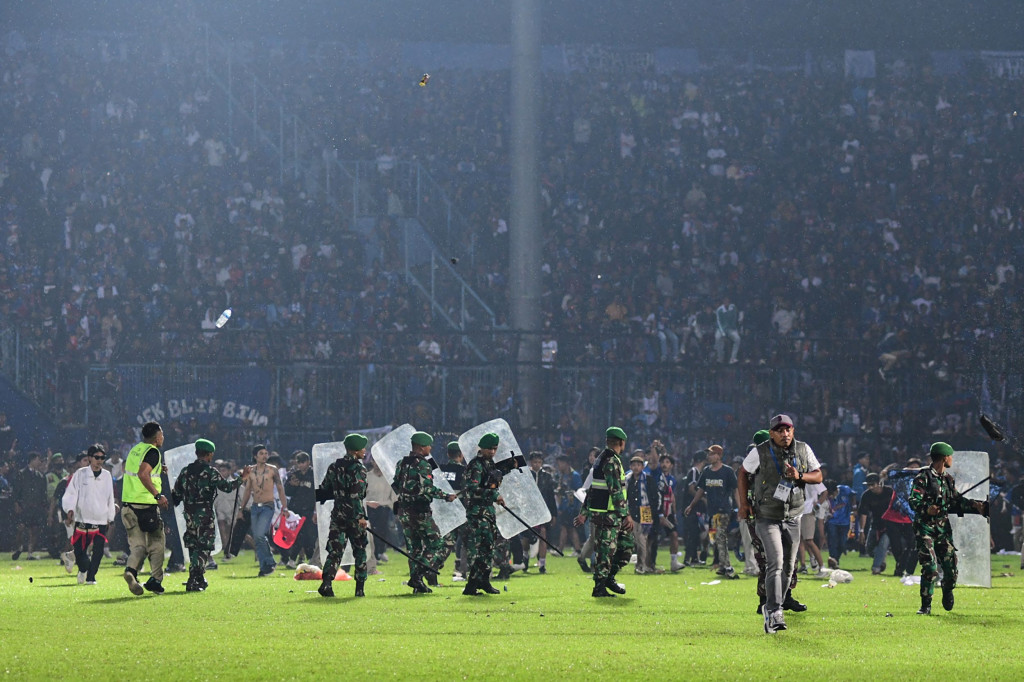 Suporter Arema FC memasuki lapangan setelah tim yang didukungnya kalah dari Persebaya dalam pertandingan sepak bola BRI Liga 1 di Stadion Kanjuruhan, Malang, Sabtu, 1 Oktober 2022. Kericuhan sendiri bermula saat para suporter Arema menyerbu lapangan usai timnya kalah melawan Persebaya. 