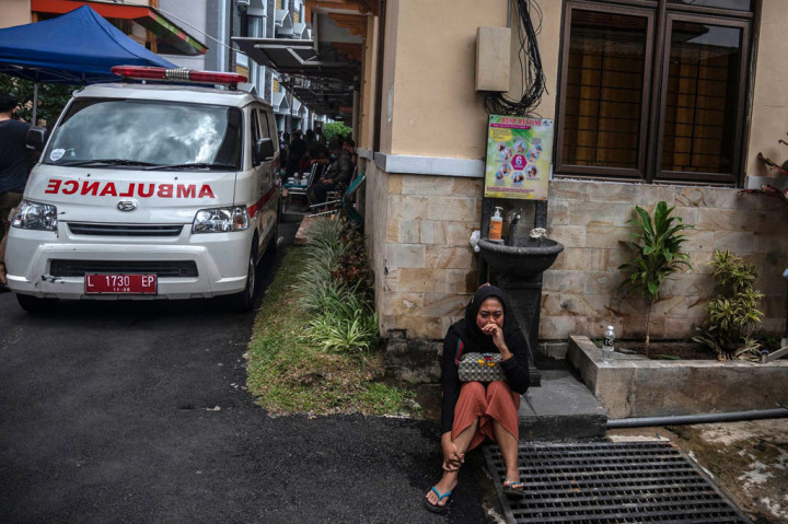 Seorang perempuan terduduk sambil berlinang air mata saat menunggu  hasil identifikasi korban tragedi Stadion Kanjuruhan Malang di sebuah rumah sakit di Malang.
