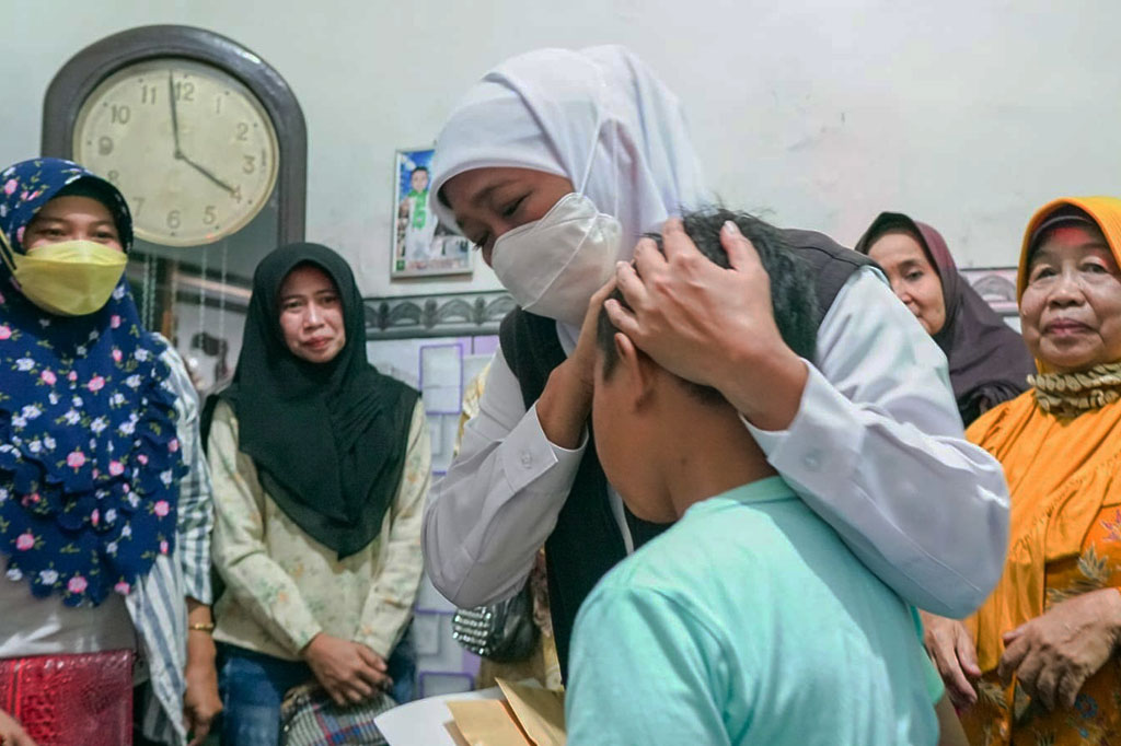 Gubernur Jawa Timur Khofifah Indar Parawansa memeluk Alviansyah, bocah 11 tahun yang menjadi yatim piatu karena kedua orangtuanya menjadi korban dalam kerusuhan di stadion Kanjuruhan, Malang, Minggu, 2 Oktober 2022.