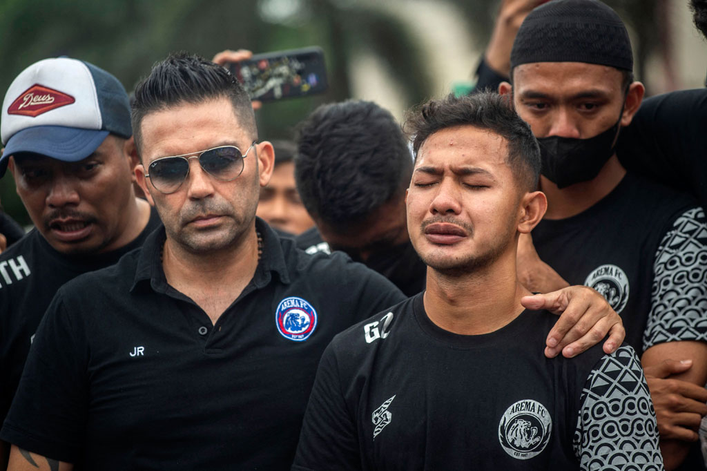 Pelatih Arema FC Javier Roca menenangkan pemain Arema Gian Zola saat tabur bunga dan doa bersama.