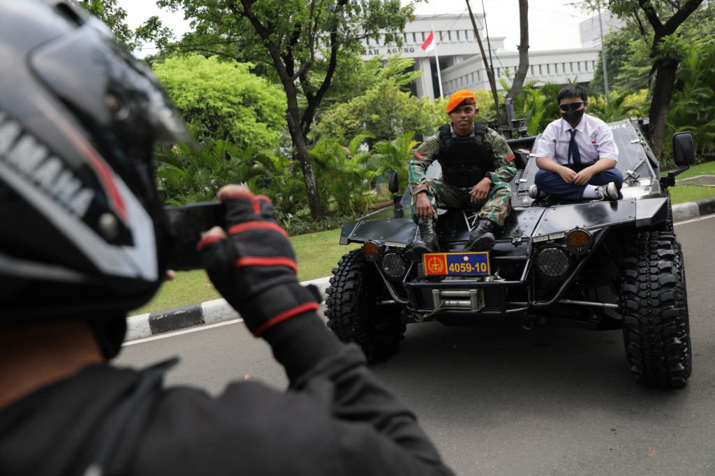 Pelajar berfoto dengan anggota TNI di atas kendaraan tempur milik TNI yang dipamerkan di depan Kompleks Istana Kepresidenan, Jalan Medan Merdeka Utara, Jakarta Pusat, Selasa, 4 Oktober 2022.