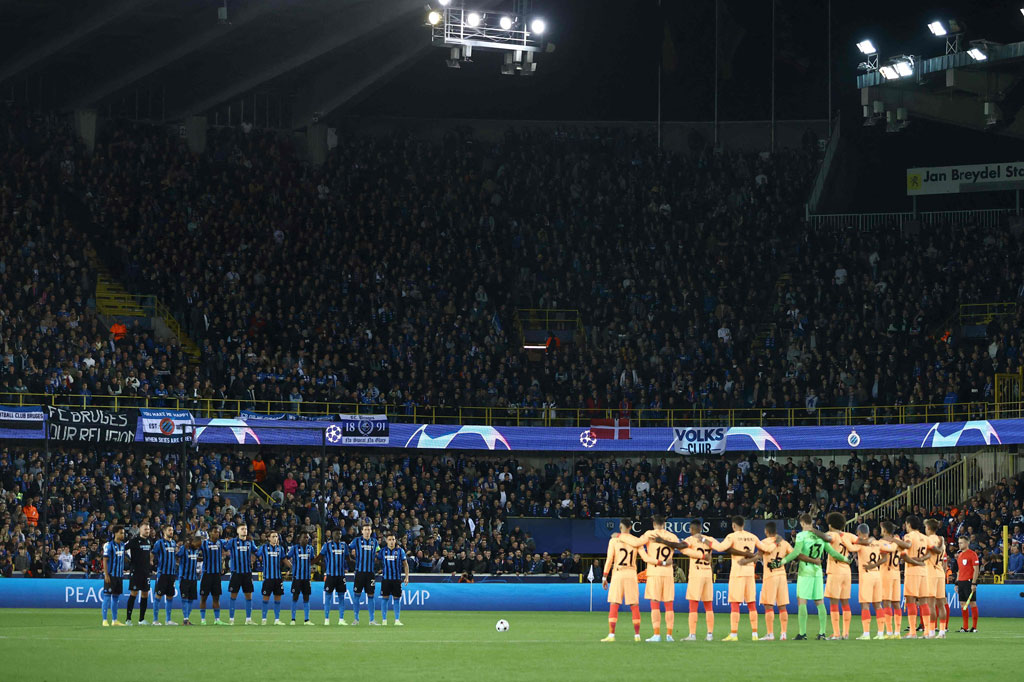 Para pemain Club Brugges (kiri) dan Atletico Madrid mengheningkan cipta selama satu menit sebelum pertandingan sepak bola grup B Liga Champions UEFA antara Club Brugge dan Atletico Madrid di stadion Jan Breydel di Bruges pada 4 Oktober 2022. AFP PHOTO/Kenzo Triboullard