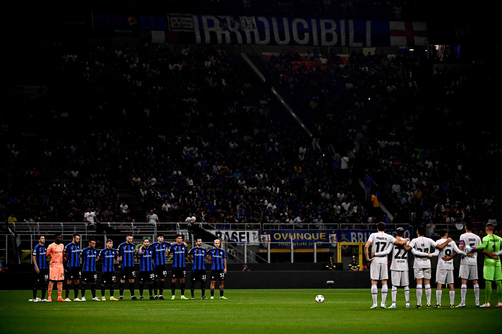 Para pemain Inter (kiri) dan Barcelona mengheningkan cipta selama satu menit untuk mengenang para korban tragedi stadion Kanjuruhan, sebelum pertandingan sepak bola Grup C Liga Champions di Giuseppe-Meazza (San Siro), di Milan. AFP PHOTO/Marco Bertorello