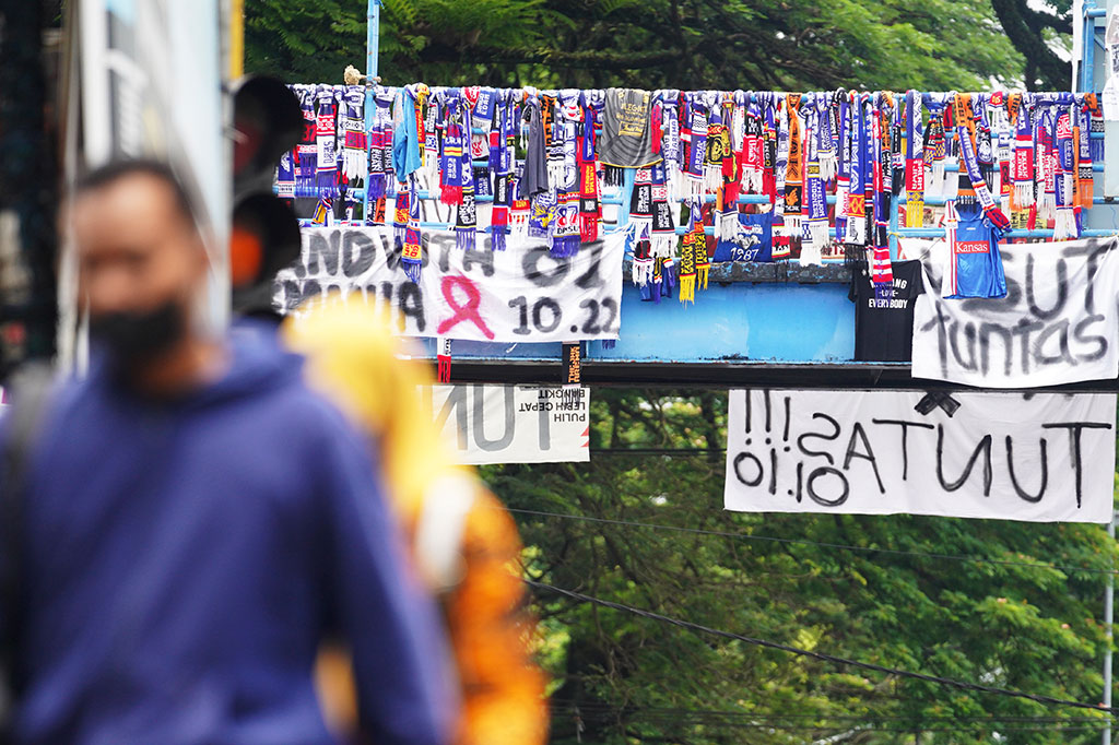 Syal milik Aremania, pendukung klub Arema FC, diikatkan di jembatan penyeberangan orang di Jl Jenderal Ahmad Yani, Malang, Jawa Timur. Hal ini sebagai bentuk keprihatinan terhadap Tragedi Kanjuruhan.