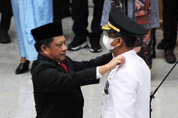 Menteri Dalam Negeri Tito Karnavian menyematkan tanda jabatan kepada Penjabat Gubernur DKI Jakarta Heru Budi Hartono (kanan) setelah dilantik di Kementerian Dalam Negeri, Jakarta, Senin, 17 Oktober 2022.