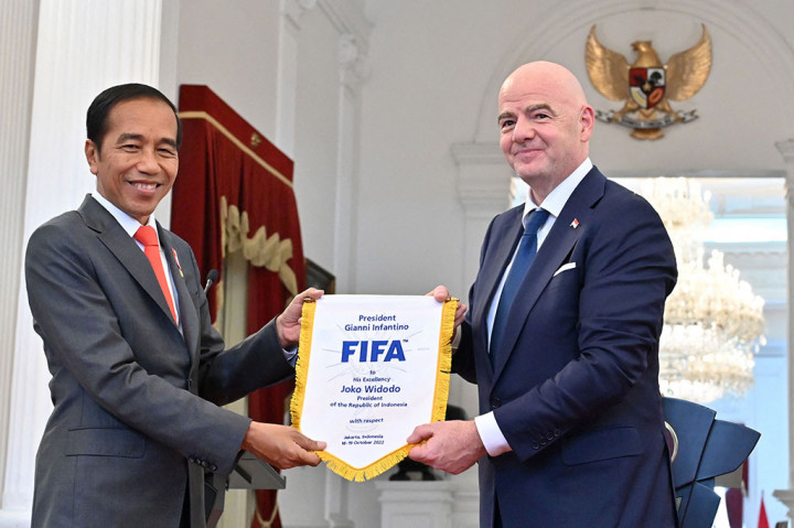 Jokowi saat menerima bendera FIFA dari Gianni Infantino.