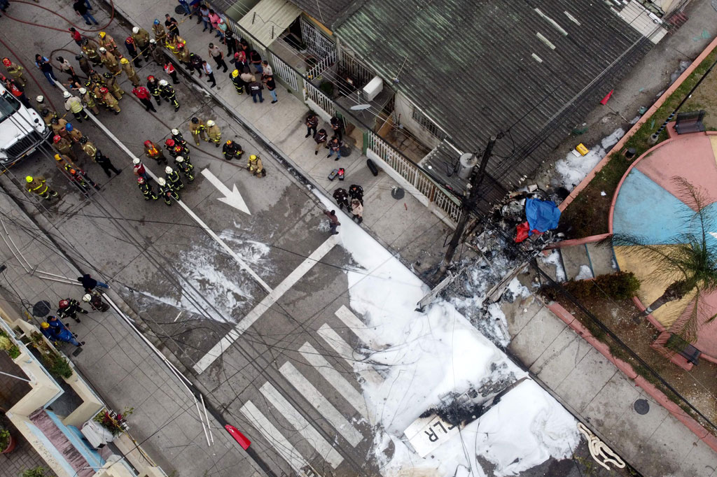 Petugas pemadam kebakaran, polisi, dan penyelamat bekerja di lokasi di mana sebuah pesawat ringan jatuh di Guayaquil, Ekuador, pada Selasa, 18 Oktober 2022.