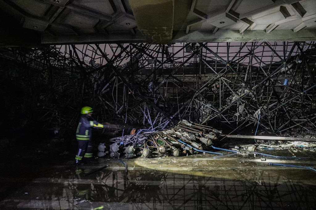 Petugas pemadam kebakaran melakukan proses pendinginan puing-puing kubah yang runtuh akibat kebakaran dari dalam ruang utama Masjid Islamic Center, Jakarta Utara, Rabu, 19 Oktober 2022, malam.