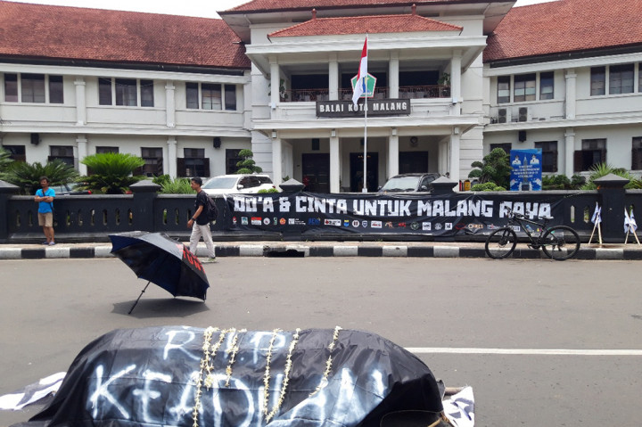 Massa menaruh sebuah replika keranda jenazah yang dibalut kain hitam bertuliskan 'RIP Hati Nurani' di depan Balai Kota Malang. 