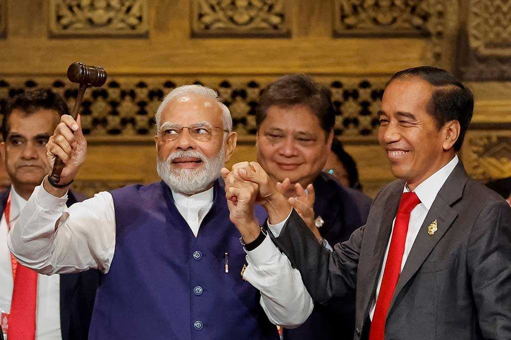Narendra Modi menunjukkan palu kepemimpinan G20 yang diserahterimakan dari Presiden Jokowi.