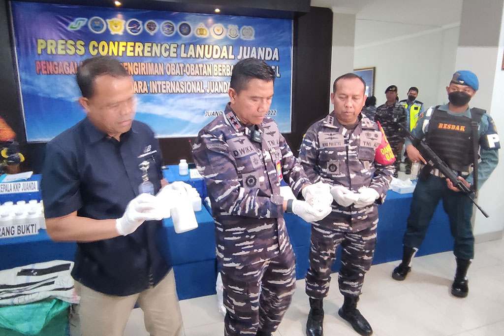 Komandan Puspenerbal Laksamana Muda Dwika Tjahja Setiawan (tengah) bersama Komandan Lanudal Juanda Kolonel Laut (P) Heru Prasetyo (kanan) dan General Manager Bandar Udara Internasional Juanda Sisyani Jafar menunjukkan barang bukti pil koplo jenis Double L saat ungkap kasus di Mako Lanudal Juanda Surabaya di Sidoarjo, Jawa Timur, Rabu, 16 November 2022.
