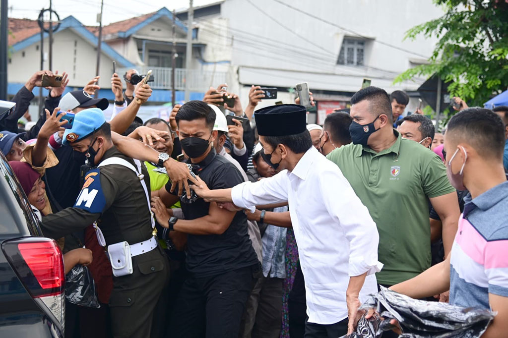 Presiden menyempatkan diri menyapa masyarakat yang hadir di sekitar masjid dan membagi-bagikan kaus.