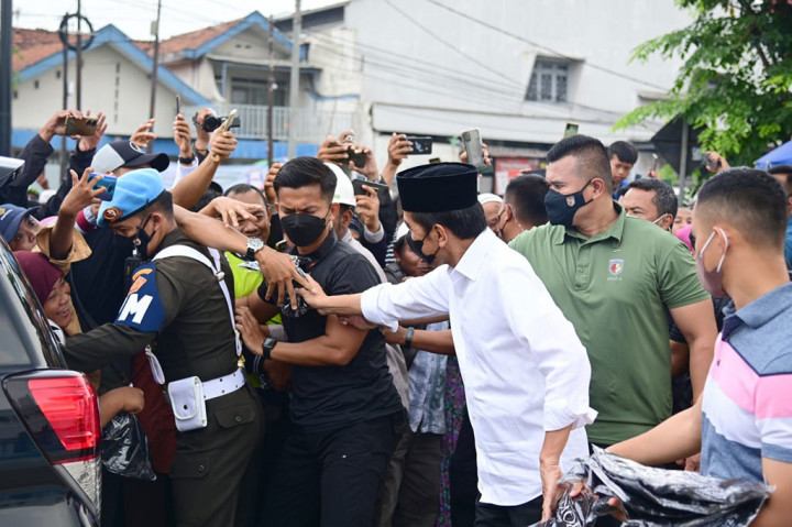 Presiden menyempatkan diri menyapa masyarakat yang hadir di sekitar masjid dan membagi-bagikan kaus.