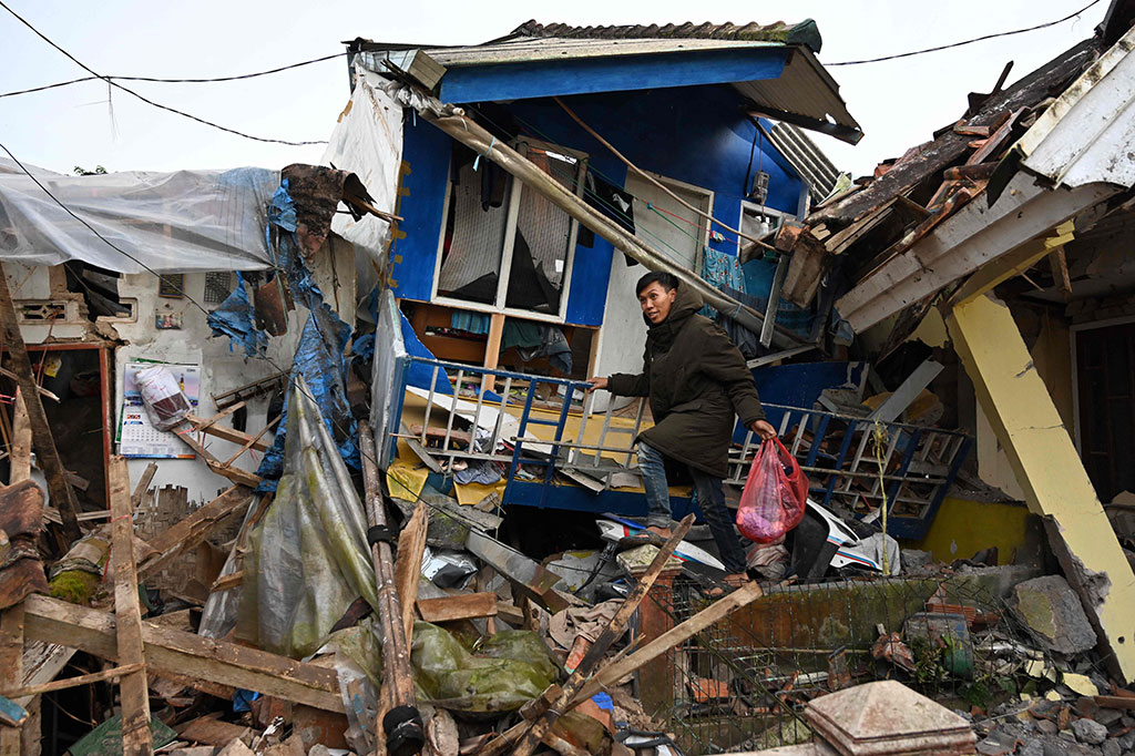 Warga mencari barang-barang yang masih bisa diselamatkan dari rumahnya yang hancur akibat gempa Cianjur.