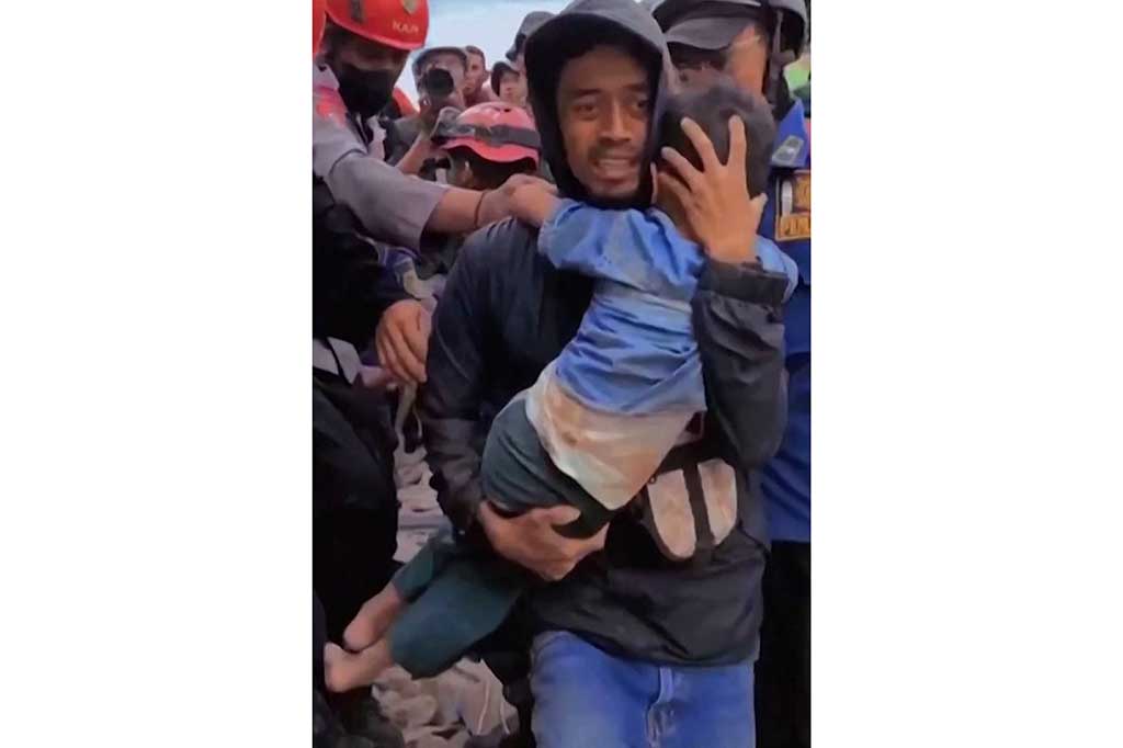 Warga membopong Azka, 6, yang diselamatkan tim SAR gabungan setelah tertimbun reruntuhan rumahnya selama tiga hari di Kampung Rawacina, Desa Nagrek, Cianjur, pada Rabu, 23 November 2022.