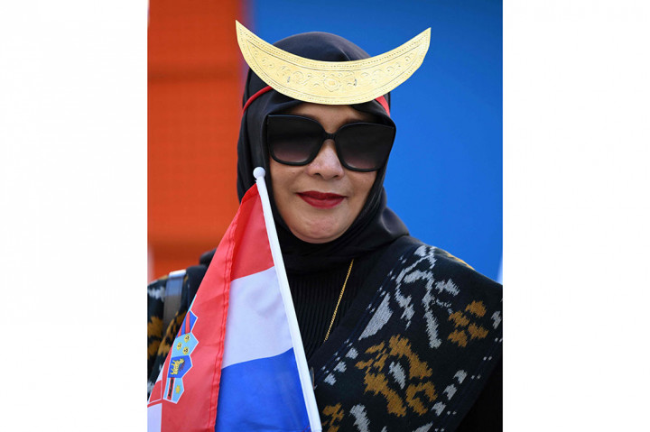 Suporter perempuan Indonesia nampal anggun dengan mengenakan pakaian adat Nusa Tenggara Timur (NTT).