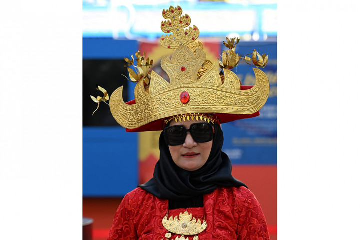 Suporter perempuan Indonesia nampal anggun dengan mengenakan pakaian adat Lampung.