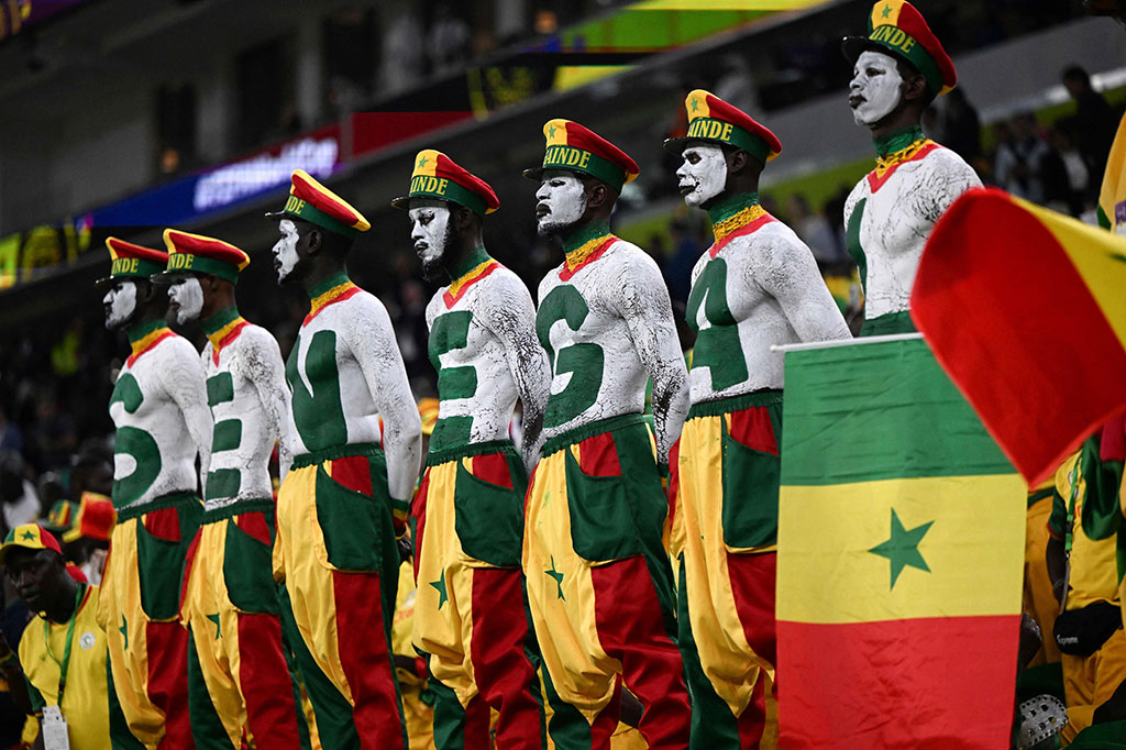 Suporter mengenakan warna khas bendera Senegal menghadiri pertandingan sepak bola Grup A Piala Dunia 2022 Qatar antara Senegal dan Belanda di Stadion Al-Thumama, Doha, Senin, 21 November 2022. AFP PHOTO/Ozan Kose