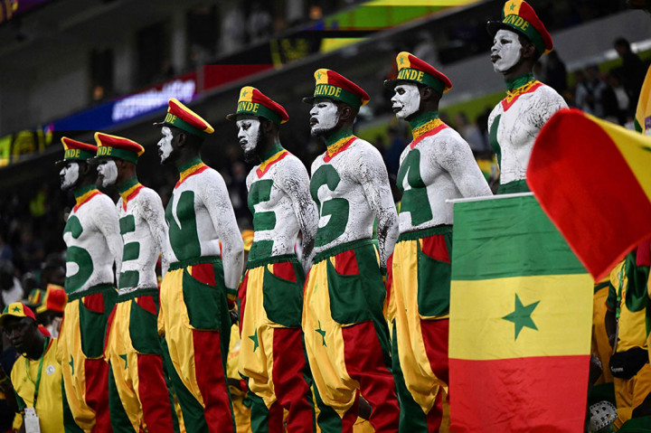 Suporter mengenakan warna khas bendera Senegal menghadiri pertandingan sepak bola Grup A Piala Dunia 2022 Qatar antara Senegal dan Belanda di Stadion Al-Thumama, Doha, Senin, 21 November 2022. AFP PHOTO/Ozan Kose