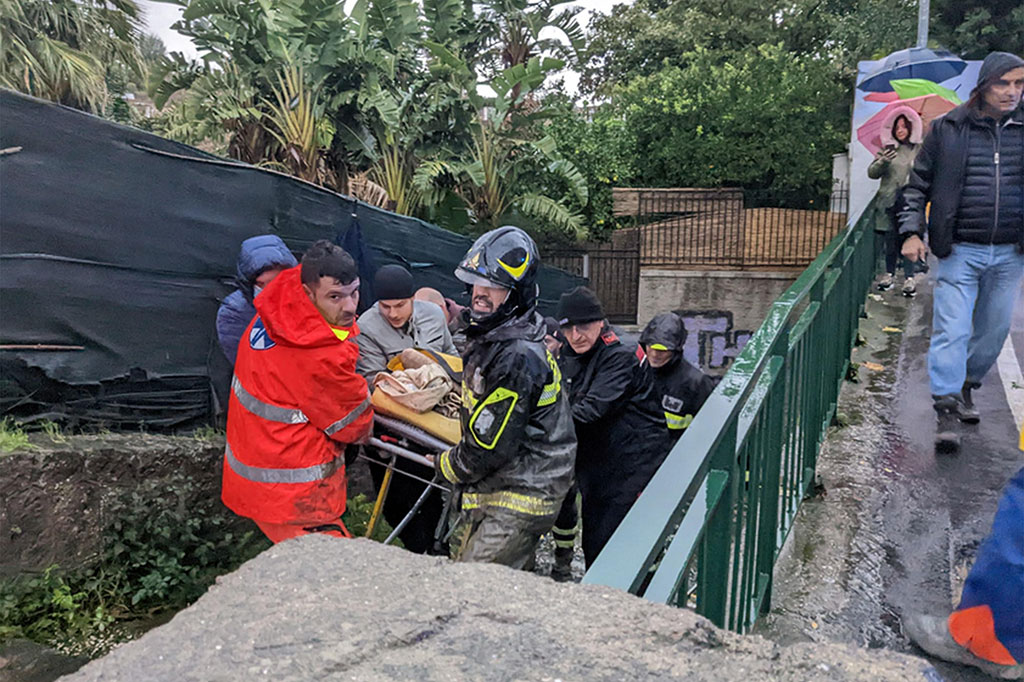 Petugas pemadam kebakaran Italia mengevakuasi seorang pria keluar dari rumahnya yang diterjang longsor di Casamicciola di Pulau Ischia selatan, Italia, Jumat, 25 November 2022 waktu setempat.