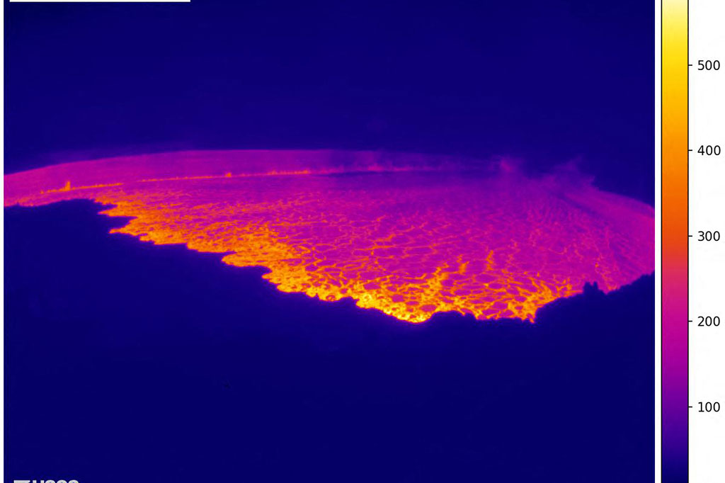 Sebuah webcam USGS di tepi utara puncak Mauna Loa menunjukkan celah letusan panjang yang terang di dalam kawah gunung berapi, kontras dengan kegelapan malam.