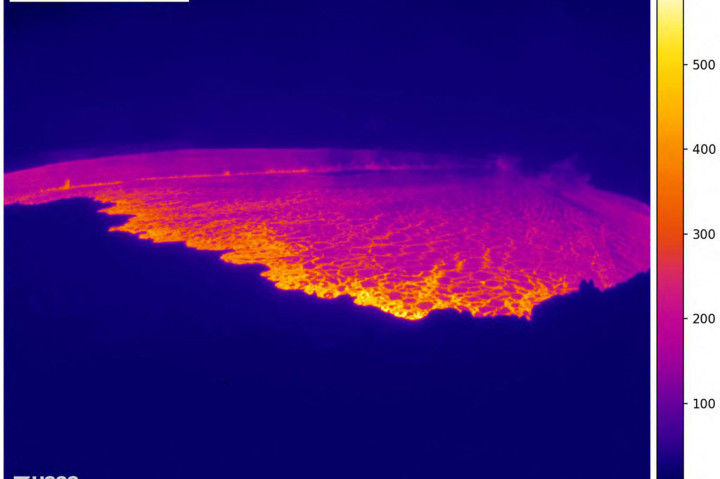 Sebuah webcam USGS di tepi utara puncak Mauna Loa menunjukkan celah letusan panjang yang terang di dalam kawah gunung berapi, kontras dengan kegelapan malam.