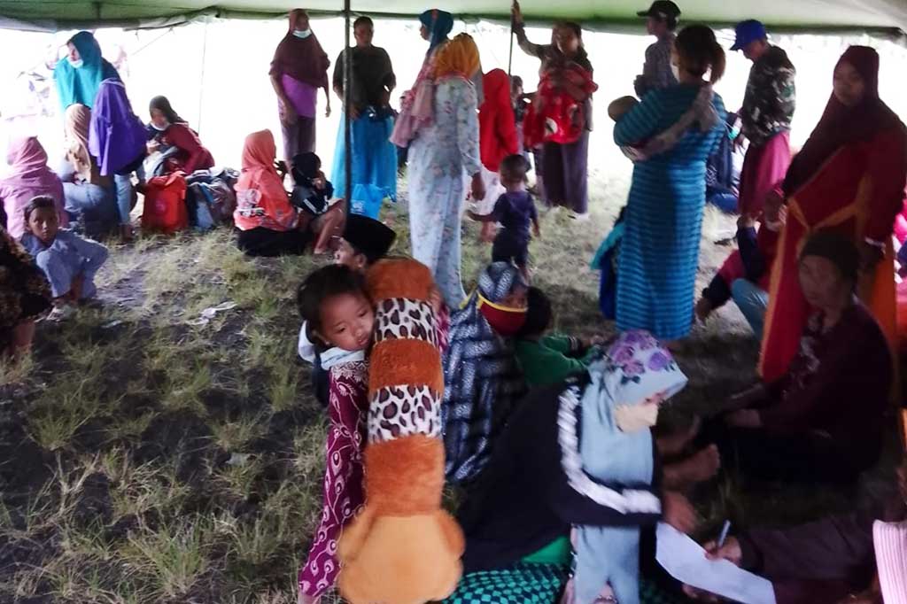Akibat erupsi Semeru, Desa Sumberwuluh dikosongkan dari semua aktivitas. Ratusan warga menyelamatkan diri dan berkumpul menempati tenda pengunsian di Lapangan Candipuro. Pengungsi terus berdatangan karena cuaca gelap, banjir pun mulai datang menggenangi sungai.
