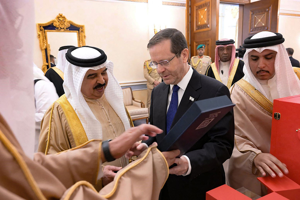 Raja Bahrain Hamad bin Isa al-Khalifa (kiri) menerima hadiah dari Presiden Israel Isaac Herzog di Kota Manama, pada Minggu, 4 Desember 2022. Herzog tiba di Bahrain, hari minggu, kunjungan pertama kepala negara Israel ke kerajaan kecil Teluk sejak normalisasi hubungan kedua negara pada 2020. 