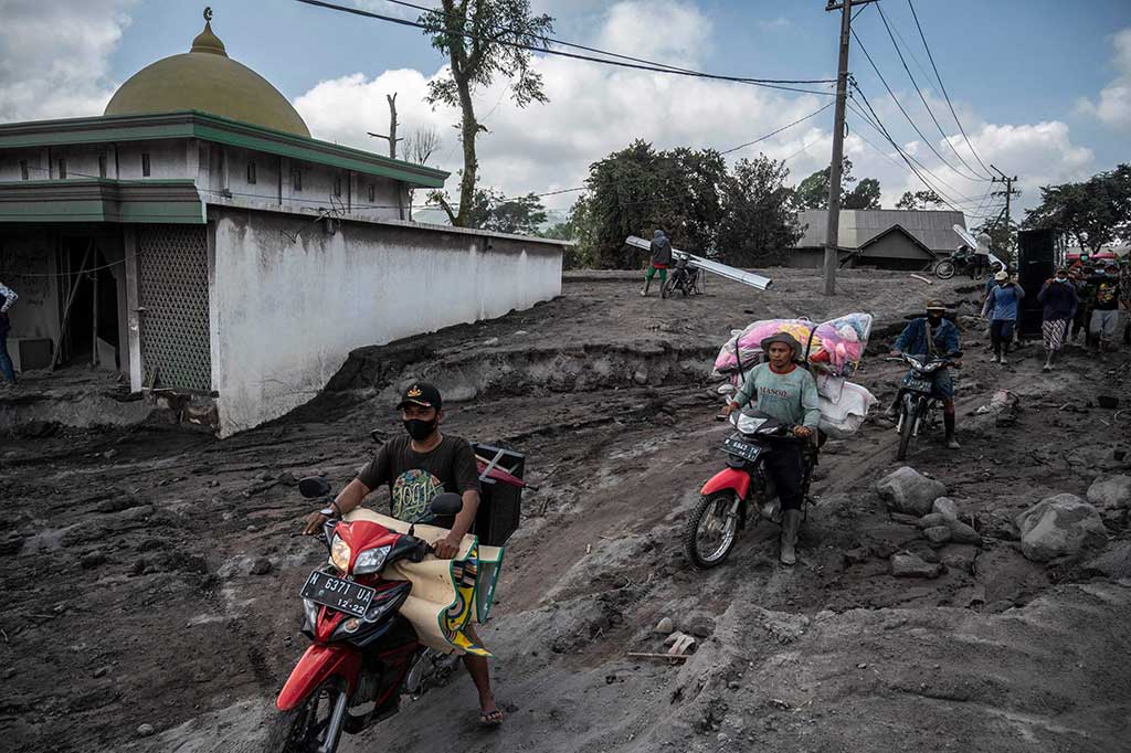 Pengungsi mengambil barang dari rumah mereka untuk dibawa ke posko pengungsian.