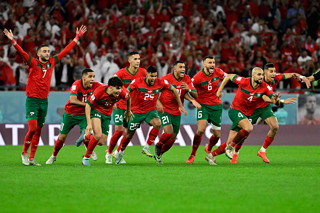Para pemain Maroko berselebrasi usai Achraf Hakimi sukses melaksanakan tugasnya sebagai algojo, sekaligus mengantarkan skuad asuhan Walid Regragui untuk pertama kalinya melangkah ke perempat final Piala Dunia.