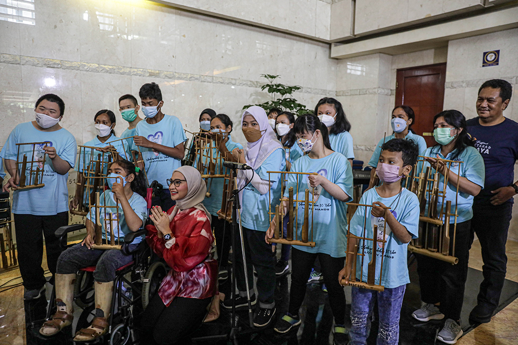 Staf Khusus Presiden Bidang Sosial Angkie Yudistia (tengah) didampingi Direktur Utama Media Indonesia Gaudensius Suhardi (kanan belakang) bersama anak-anak penyandang disabilitas saat bermain alat musik Angklung pada pembukaan Festival Setara dan Berdaya. Rangkaian kegiatan Festival Setara dan Budaya terdiri atas pameran, pelatihan, dan hiburan. Acara ini terbuka untuk para disabilitas, para pegiat dunia disabilitas, serta masyarakat umum.