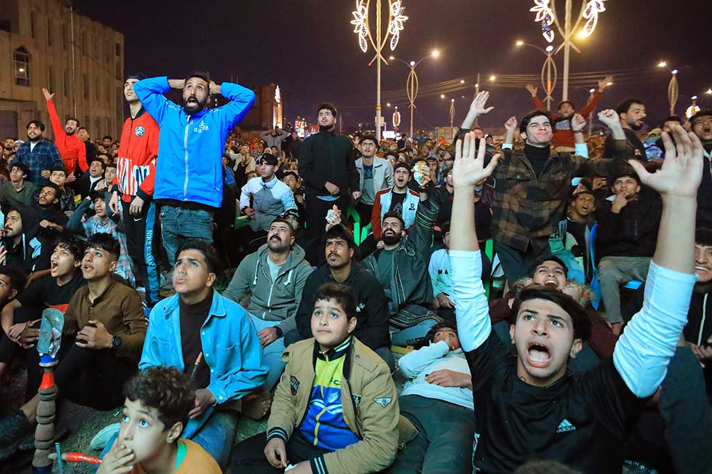 Para penggemar sepak bola Irak bereaksi saat menyaksikan pertandingan sepak bola semifinal Piala Dunia Qatar 2022 antara Maroko dan Prancis, di kota Nasiriyah, Irak selatan, ibu kota provinsi Dhi Qar, pada 14 Desember 2022. AFP PHOTO/Asaad Niazi